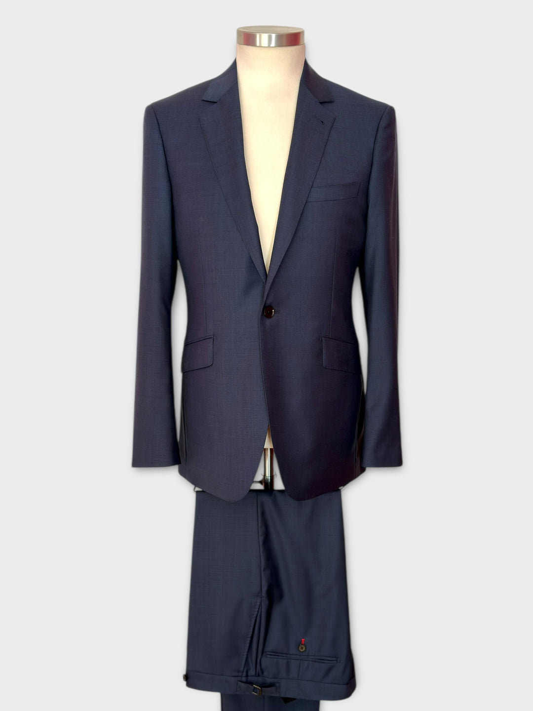 Navy blue suit on a mannequin against a white background