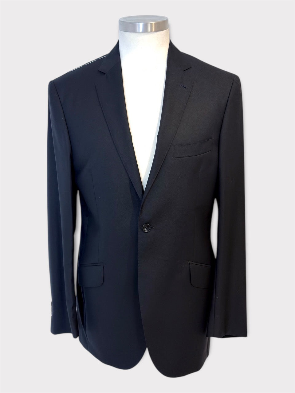 Black suit jacket on a mannequin against a white background