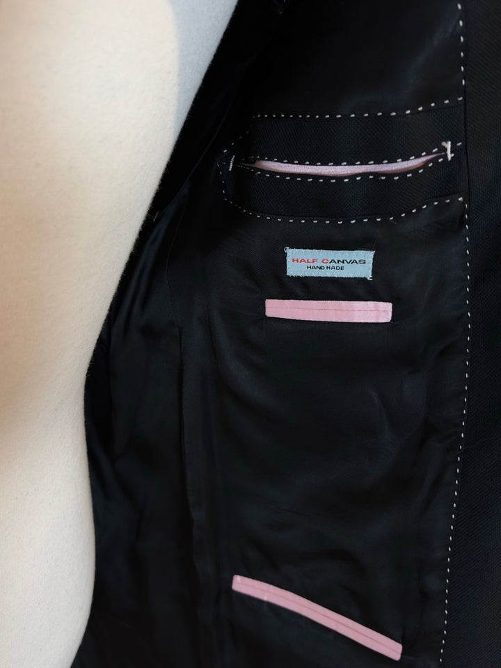 Close-up of a black jacket with pink accents and a visible brand label.